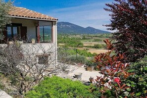 Ein Haus mit einem Balkon mit Blick auf eine gebirgige Landschaft.