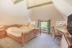 Un dormitorio con una cama de madera, un escritorio, una silla y una ventana con cortinas.