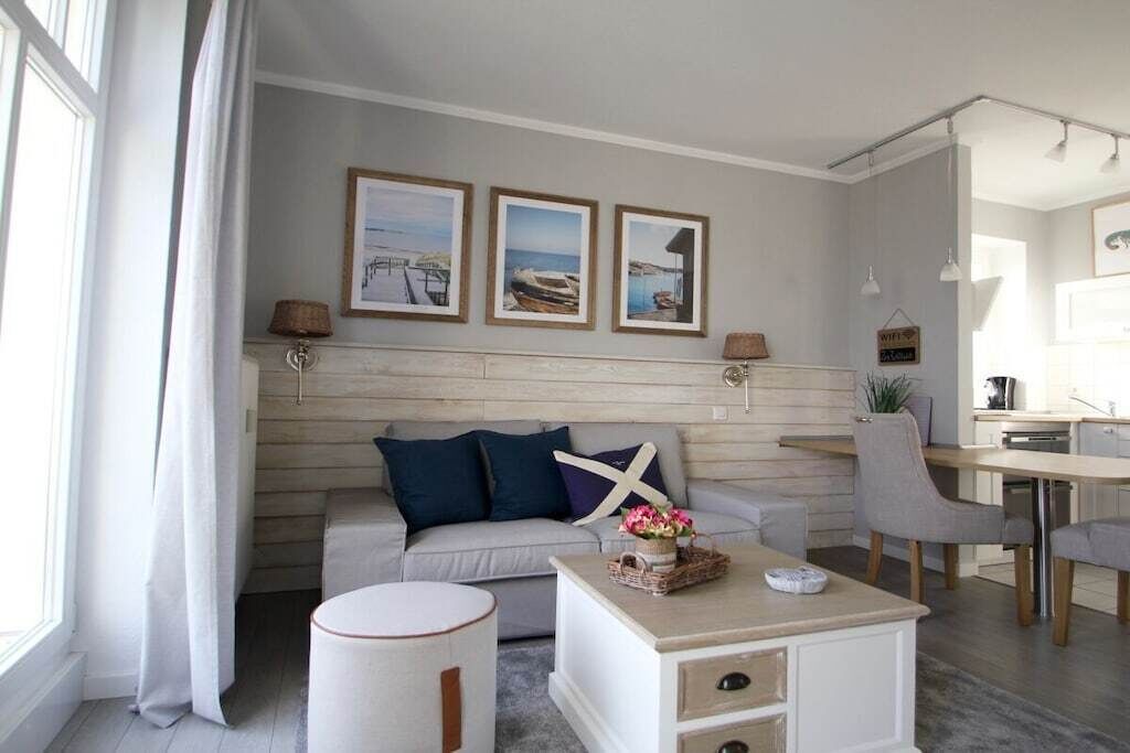 A modern living room with a sofa, coffee table, and artwork on the wall.