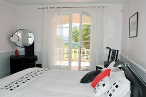 A bedroom with a bed, a bedside table, a mirror, and a view of the outdoors through a door. - Villa in Villedieu with swimming pool (Villedieu)