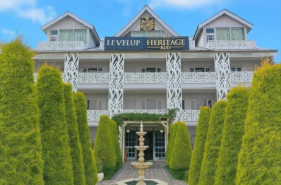 A hotel with a sign reading 'LEVELUP HERITAGE KUD' and a decorative fountain in the entrance.