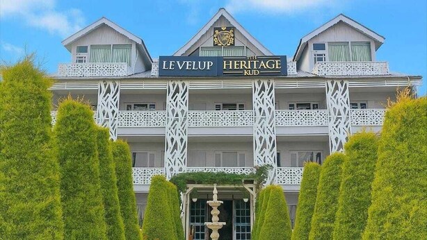 A hotel with a sign reading 'LEVELUP HERITAGE KUD' and a decorative fountain in the entrance. - The Heritage Kud (Patnitop)