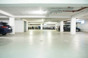 A multi-level parking garage with concrete floors and white pillars. - Holiday apartment with 1 bedroom (St. Peter-Ording)