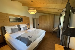 A bedroom with a bed, a chair, a desk, and a wardrobe. - Cabin in Inzell with swimming pool (Inzell)