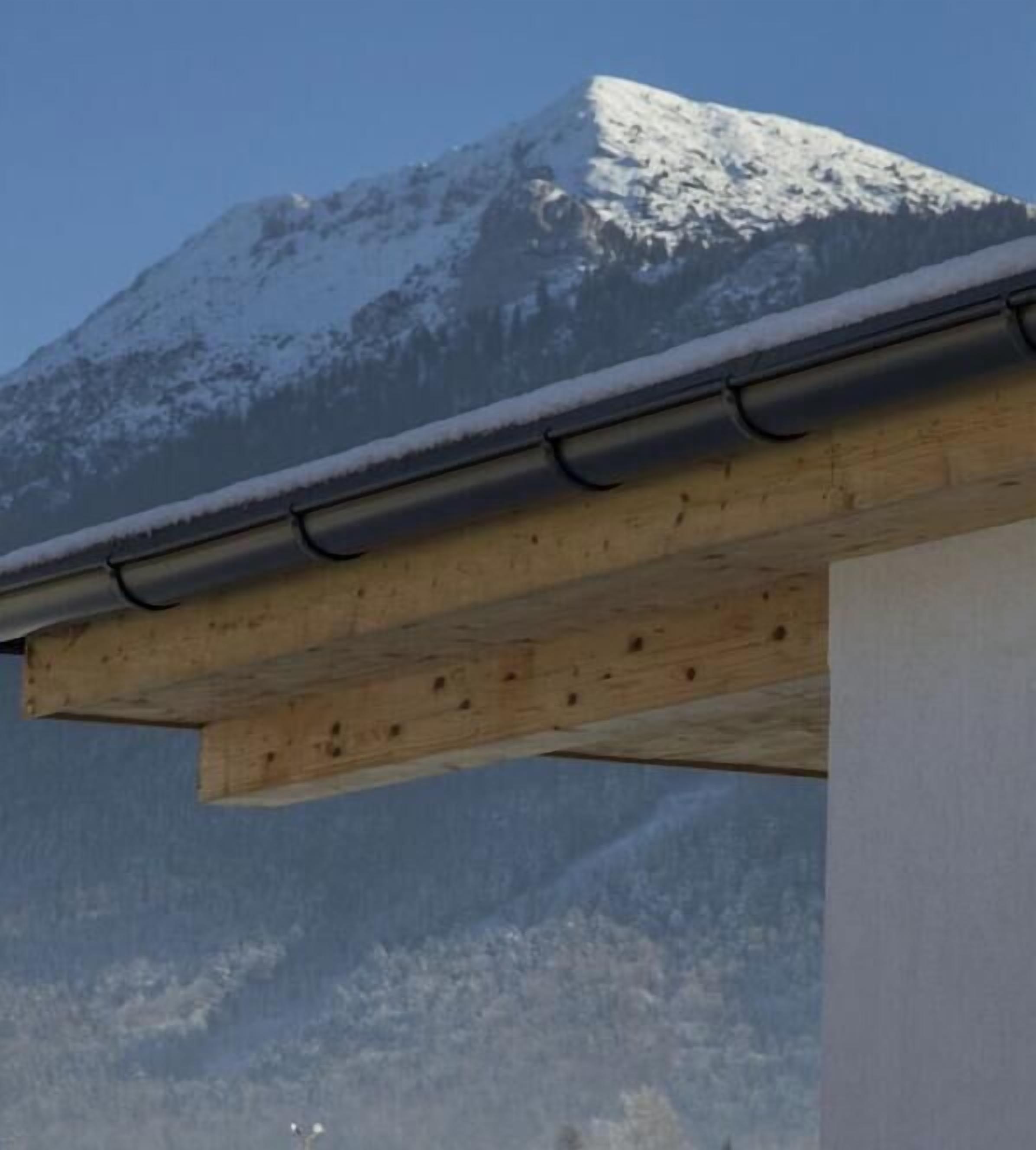 A wooden structure with a metal gutter, likely part of a building's exterior.
