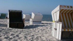 Beach chairs arranged on a sandy beach with the ocean in the background. - Holiday apartment with 4 bedrooms (Wangerooge)