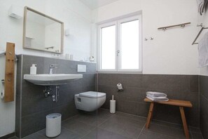 A modern bathroom with a sink, toilet, and a window. - Holiday apartment with 2 bedrooms (Chieming)