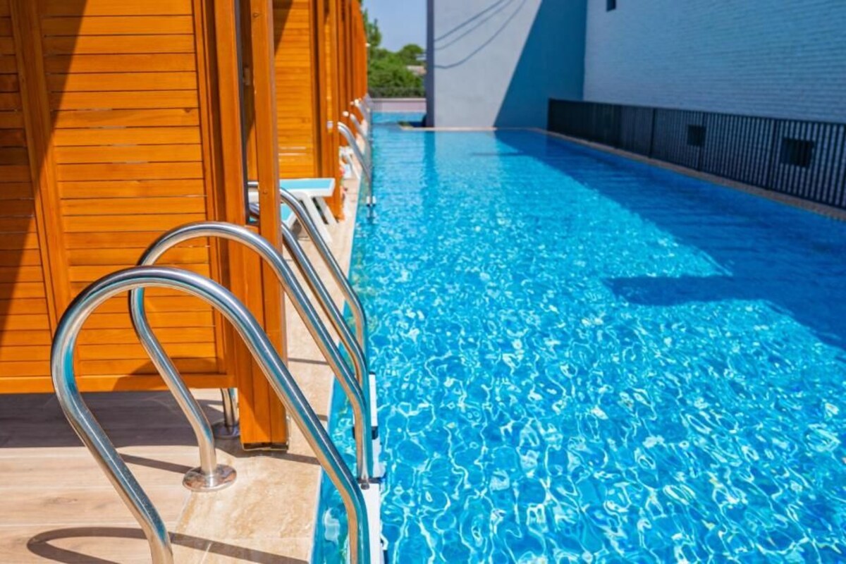 Une piscine avec des rampes en métal et des parois en bois.