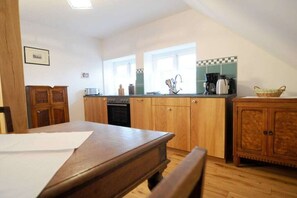 A kitchen with wooden cabinets, a countertop, and a window. - Holiday apartment with 2 bedrooms (Wunstorf - Idensen)