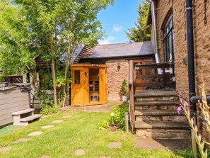 A rustic stone building with a wooden door and a small porch. - The Warm Hearth: 15 Acre Countryside Estate (Hereford)