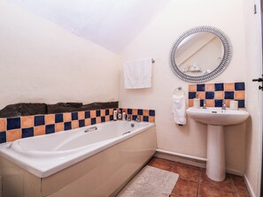A bathroom with a bathtub, a sink, a mirror, and a towel rack. - The Warm Hearth: 15 Acre Countryside Estate (Hereford)