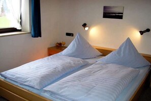 A double bed with two pillows and a bedside table with a lamp and a glass of orange juice. - Holiday apartment with 2 bedrooms (Schönau am Königssee)