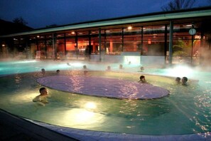 Een deel met een jacuzzi, omgeven door glas, en een klok.