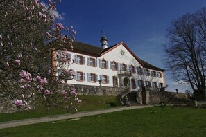 A large, historic building with a symmetrical facade, multiple windows, and a prominent entrance with steps. - Blauenblick House at Kirchblick (Schliengen)