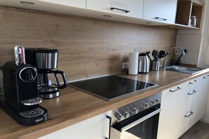 A modern kitchen with a coffee maker, a kettle, a toaster, and a sink. - Holiday apartment with 2 bedrooms (Sankt Andreasberg)