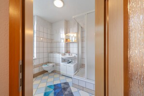 Ein Badezimmer mit Toilette, Waschbecken und Dusche.