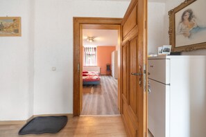 Un pasillo que conduce a un dormitorio con cama, un radiador y un armario.