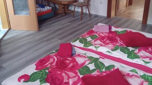 A bedroom with a bed, a desk, and a chair. There is a television on the wall. - Apartment 'Dreibettzimmer Am See' with Shared Terrace, Shared Garden and Wi-Fi (Schkeuditz)