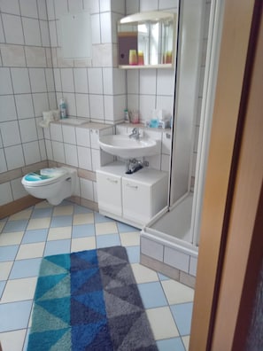Un baño con inodoro, lavamanos y ducha.