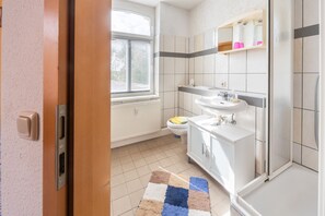 A bathroom with a toilet, sink, and shower. - Apartment 'Einzelzimmer Am See' with Shared Terrace, Shared Garden and Wi-Fi (Schkeuditz)