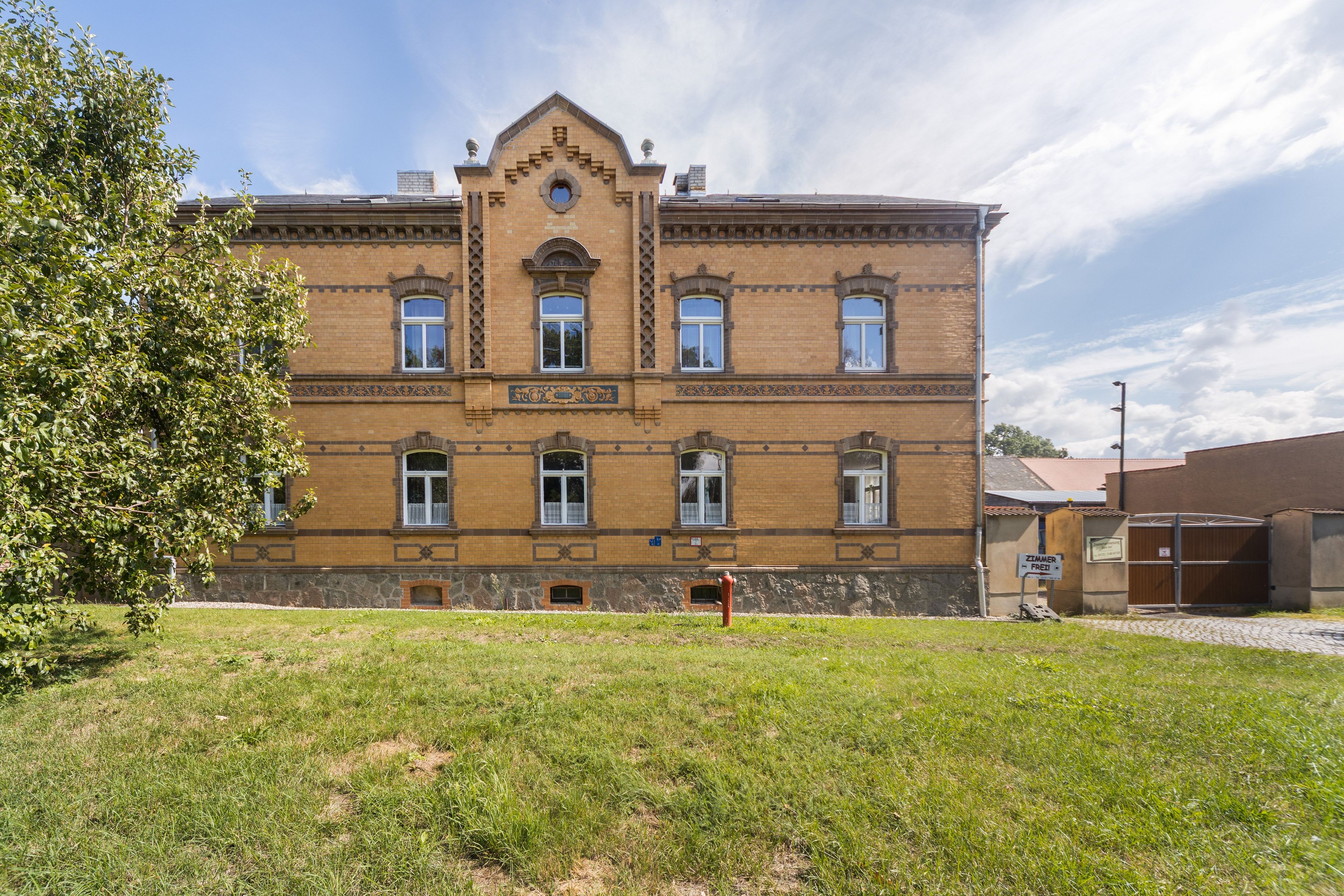 A large, historic building with a symmetrical facade, multiple windows, and a central entrance.