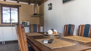 Een houten eettafel met geweven placematen, een afstandsbediening en een bord eten.