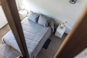 A bedroom with a bed, two bedside tables, and a nightstand.