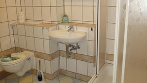 Un baño con inodoro, lavabo y ducha.