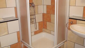 Ein Badezimmer mit Duschkabine, Toilette und Waschbecken.