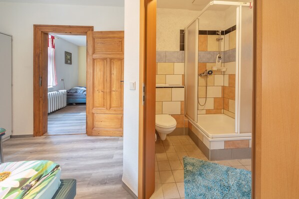 A bathroom with a shower, toilet, and a bathtub.