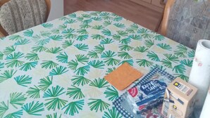Une pièce comprenant une table à manger, des chaises, un réfrigérateur, une armoire et une poubelle.