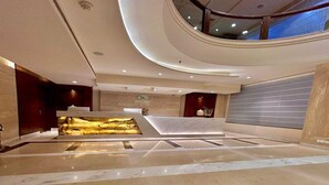 A modern lobby with a reception desk, a decorative wall feature, and a high ceiling with recessed lighting. - Superior Checkin Amritsar (Amritsar)