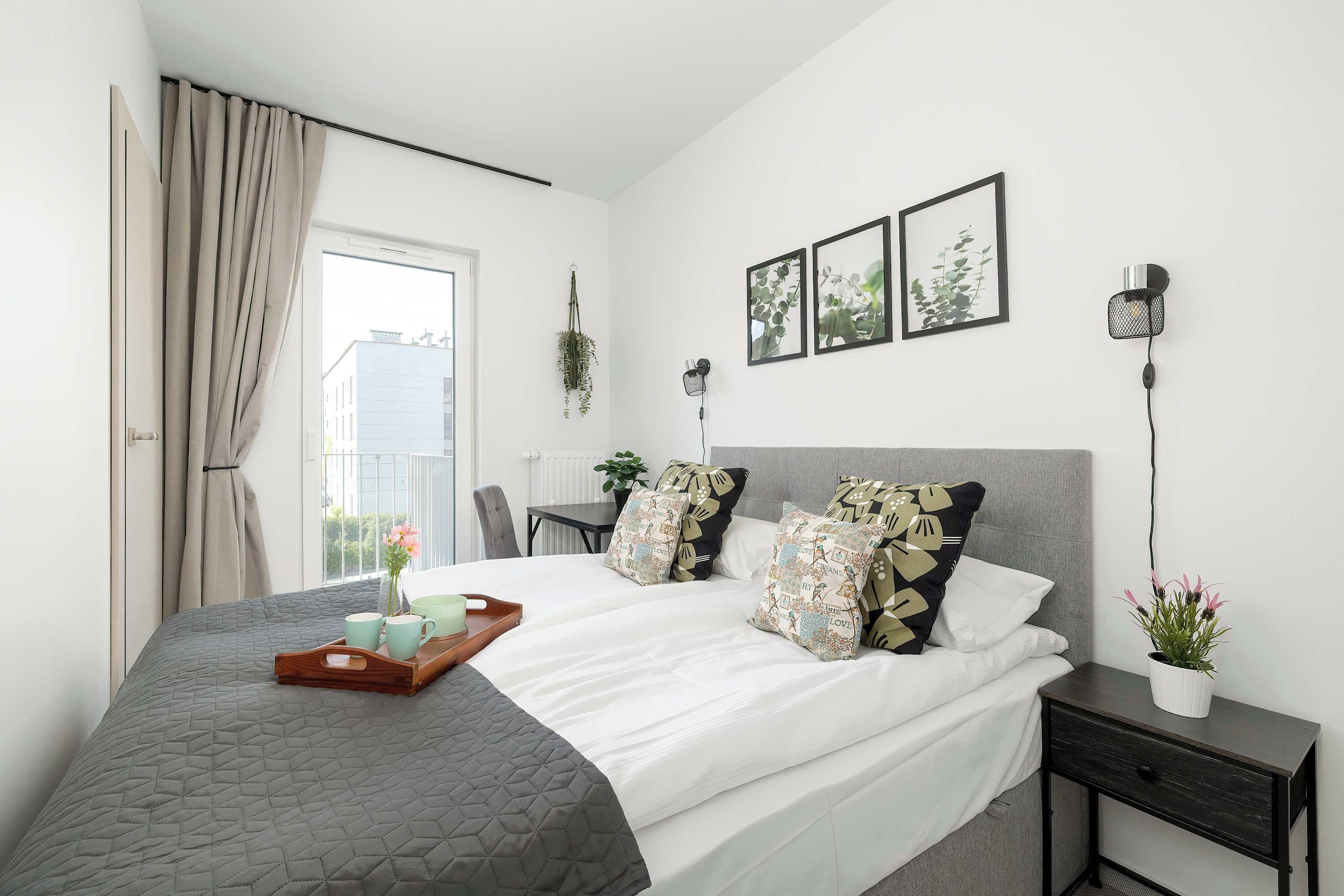 Quarto moderno com cama, mesas de cabeceira, escrivaninha e janela com cortinas.