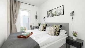 Une chambre moderne avec un lit, des tables de chevet, un bureau et une fenêtre avec des rideaux.