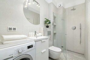 A modern bathroom with a washing machine, a toilet, a sink, and a shower. - Modern Apartment with Balcony | Desk | Parking (Kraków)