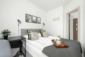 Een moderne slaapkamer met een bed, nachtkastje en bureau.