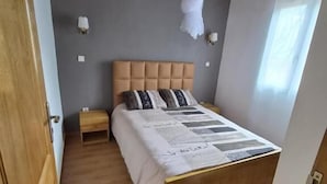 A bedroom with a bed, bedside tables, a canopy, and a window. - Charming 2-bedroom Apartment in Yaoundé - Comfortable Living (Yaoundé)