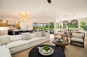 A modern living space with a kitchen, dining area, and seating. - Tranquility in Princeville (Princeville)