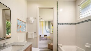 Een badkamer met een bad, wastafel, toilet en douche.