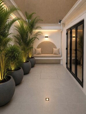 A modern interior with a seating area, potted plants, and a wall-mounted light fixture. - Provenza's Top Apt w/ Jacuzzi, AC, WD, Elevator, Located in the Best Area (Medellín)