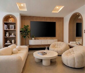 A modern living room with a large flat-screen TV, two round coffee tables, and two plush armchairs. - Provenza's Top Apt w/ Jacuzzi, AC, WD, Elevator, Located in the Best Area (Medellín)