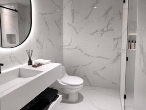 A modern bathroom with a white marble backsplash, a white sink, and a toilet. - Provenza's Top Apt w/ Jacuzzi, AC, WD, Elevator, Located in the Best Area (Medellín)
