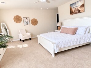 Ein Schlafzimmer mit Bett, Sessel, Schminktisch und Wandgestaltungen.