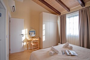 Ein Hotelzimmer mit Bett, Schreibtisch, Spiegel und einem Fenster mit Vorhängen.