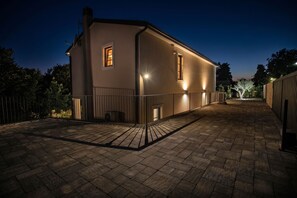 Ein zweistöckiges Gebäude mit einem gepflasterten Innenhof, einem verschlossenen Eingang und einem kleinen Fenster im oberen Geschoss.