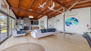 A spacious living room with a fireplace, two sofas, and a large window. - Coastal Calm at Cape Woolamai (Cape Woolamai)