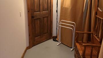 A hallway with a wooden door, a floor lamp, and a radiator.