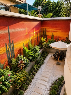 A courtyard with a cactus garden, a seating area with a table and chairs, and a gravel path. - Double Room in a Luxury Villa (New Cairo)