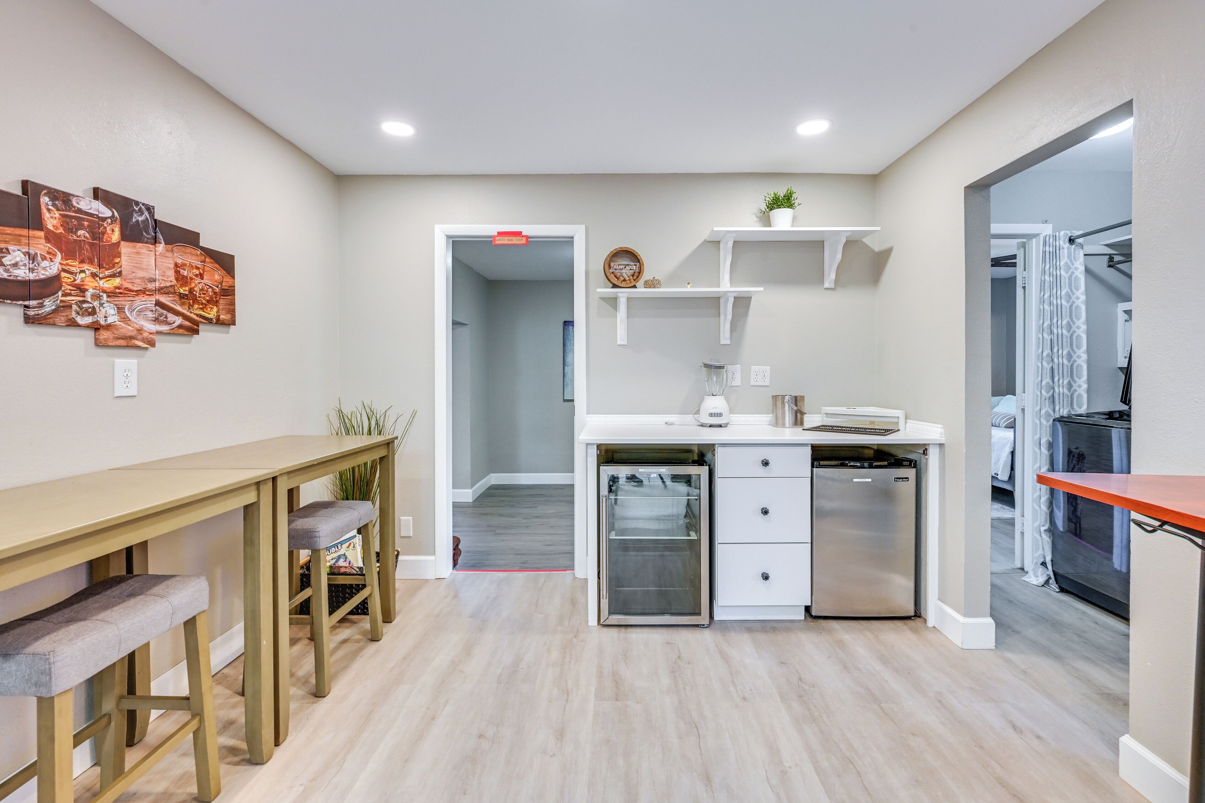 A modern kitchen with a dining area, white cabinetry, and a built-in dishwasher.