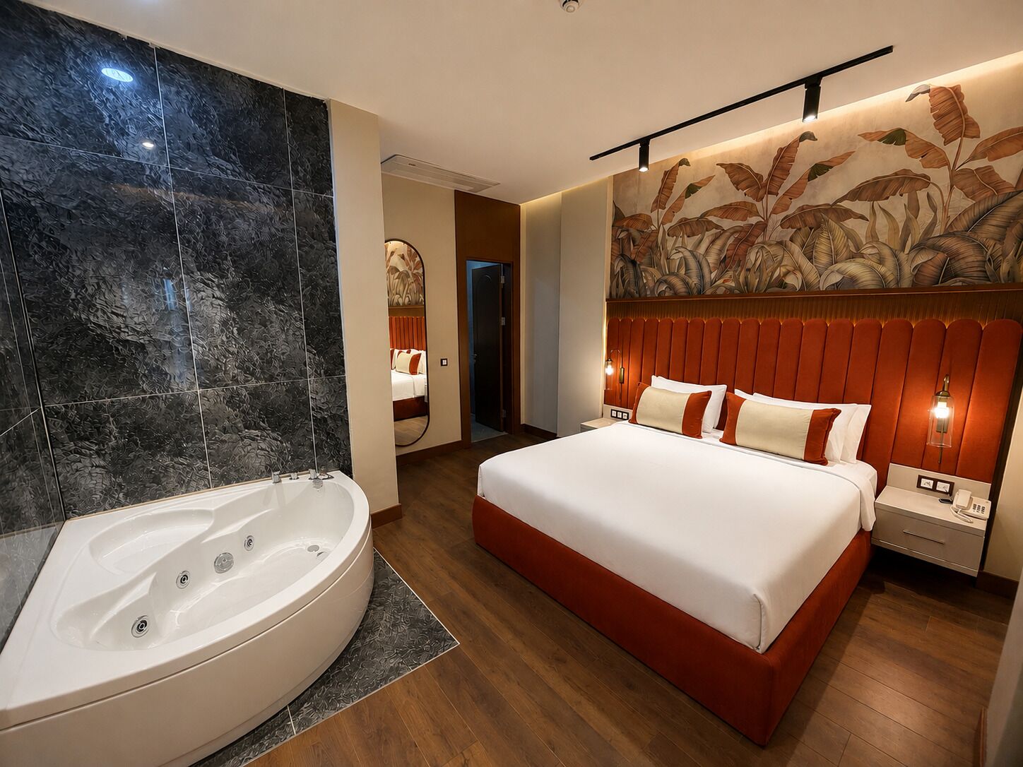 A modern hotel room with a large bed, a separate bathroom with a jacuzzi, and a decorative wall mural.